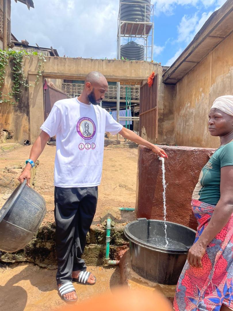 A Mafoya Foundation volunteer helping run water for a resident