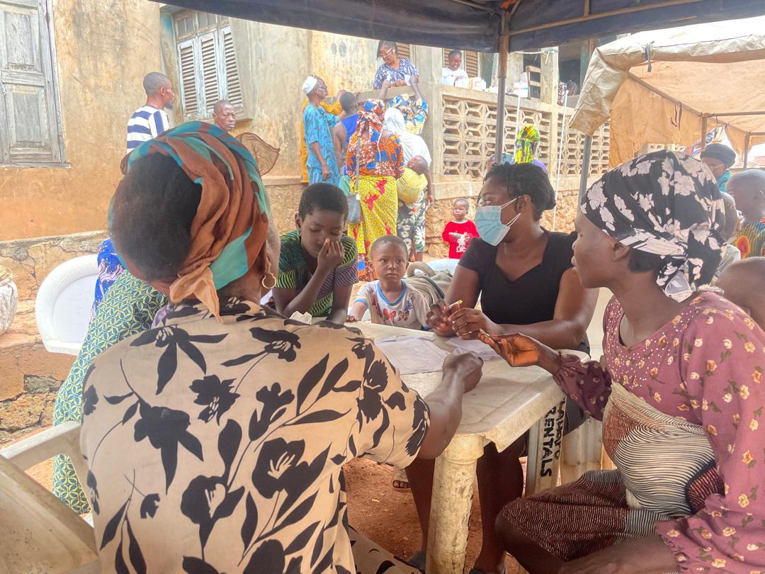 Staff attending to a mother and child at the outreach table