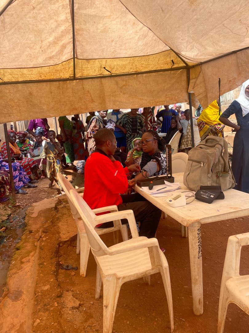 A blood pressure check under the tent with a large crowd waiting behind